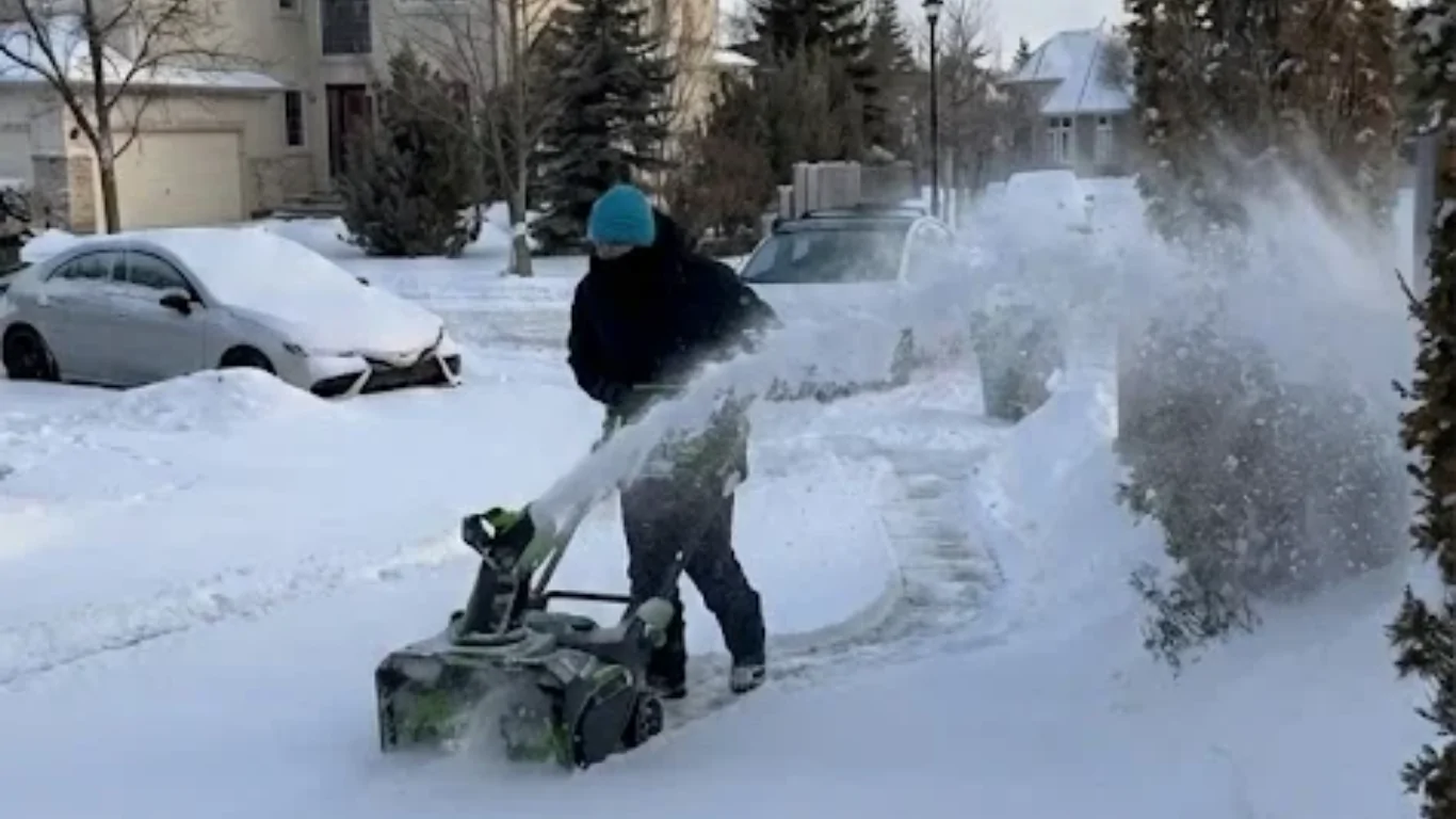 A neighbourhood heroes crew member performing snow removal services in Edmonton